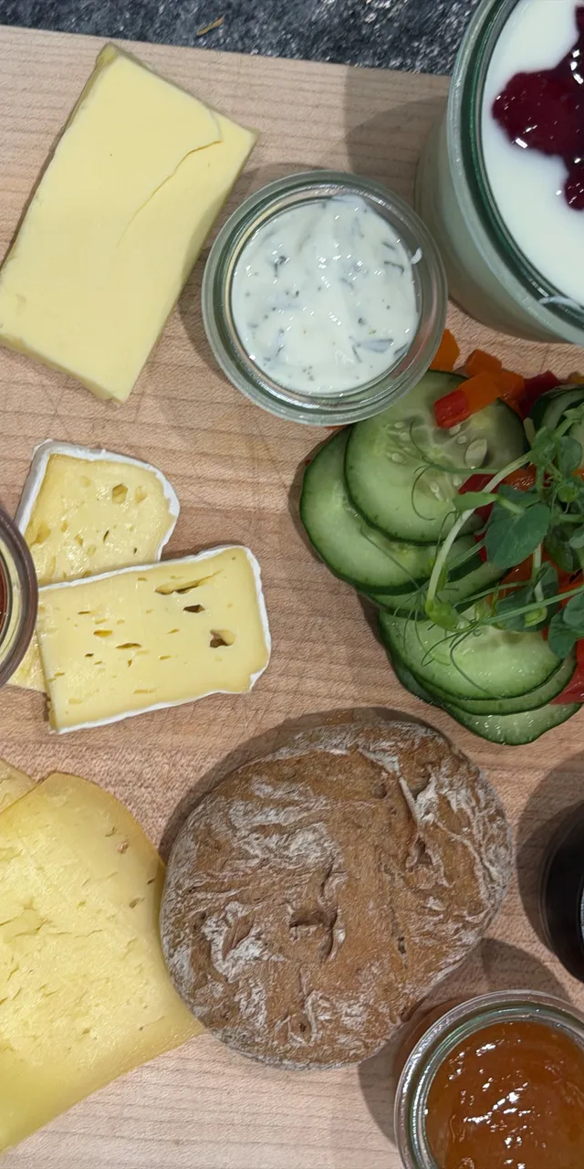 Frühstücksplatte mit Käse, Brot, Ei, Schinken, Joghurt mit Früchten und Gemüse