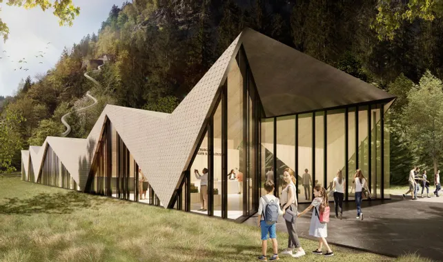 Modern visitor center with zigzag roof design set in forested mountain landscape