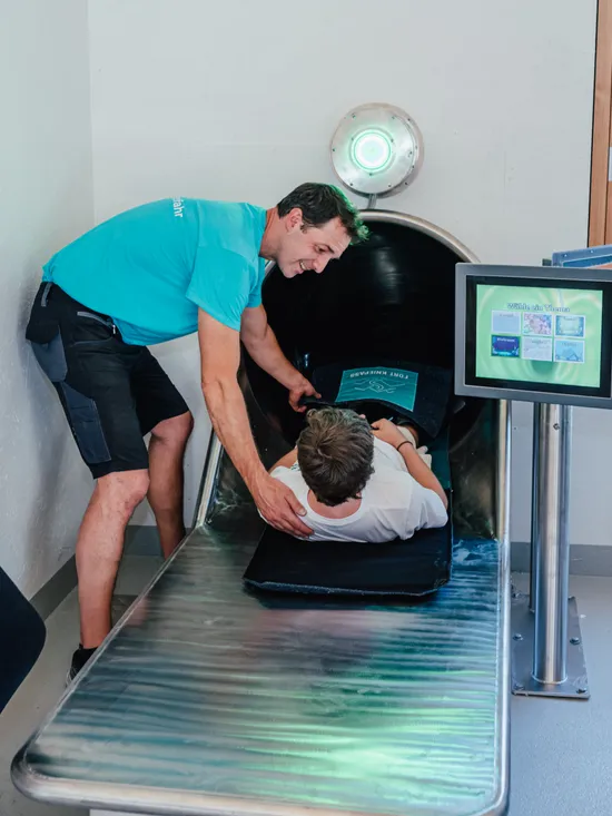 Kinder erkunden interaktive Rutschensimulation mit Betreuer im Indoor-Wissenszentrum