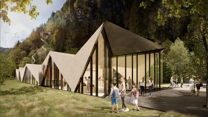 Modern visitor center with angular roof design set in forested mountain landscape
