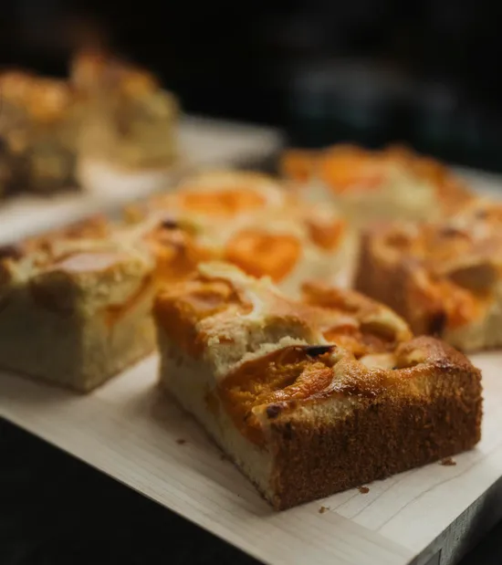 Hausgemachte Aprikosen-Blechkuchenscheiben auf Holzbrett