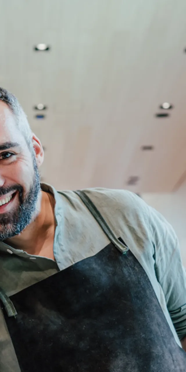 Smiling restaurant owners serving fresh pizza, salad, pasta, and sandwich in modern eatery
