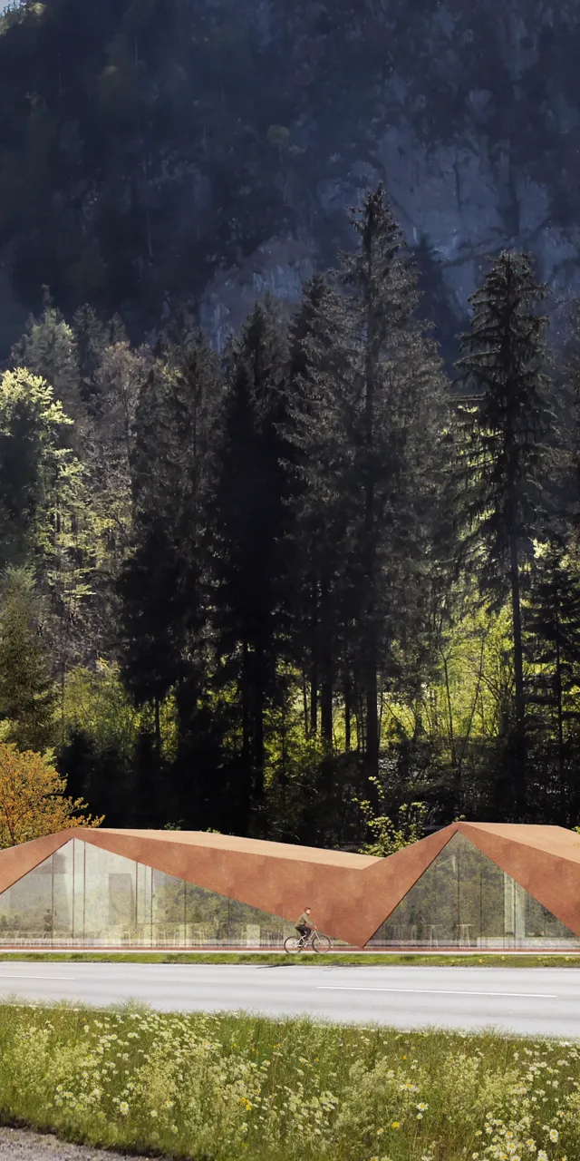 Modernes Besucherzentrum mit schrägem Dach in bewaldeter Berglandschaft an einer kurvigen Straße