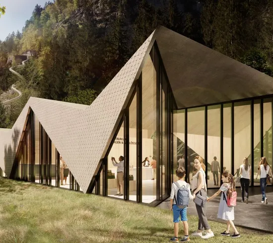Modern visitor center with zigzag roof design set in forested mountain landscape